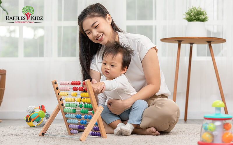 Happy Asian young mother and daughter playing with abacus, early education at home
