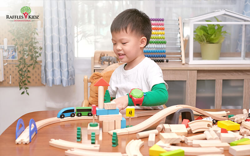 Child happily playing with wooden toys at preschool.